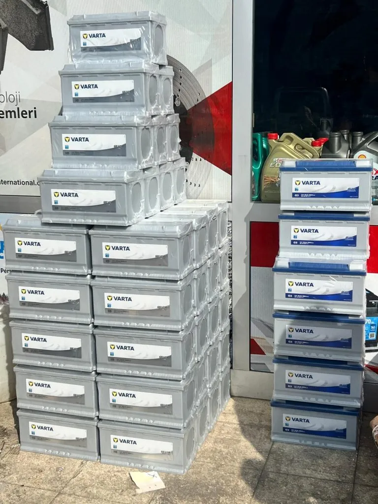 Dükkân önünde istiflenmiş büyük gümüş aküler