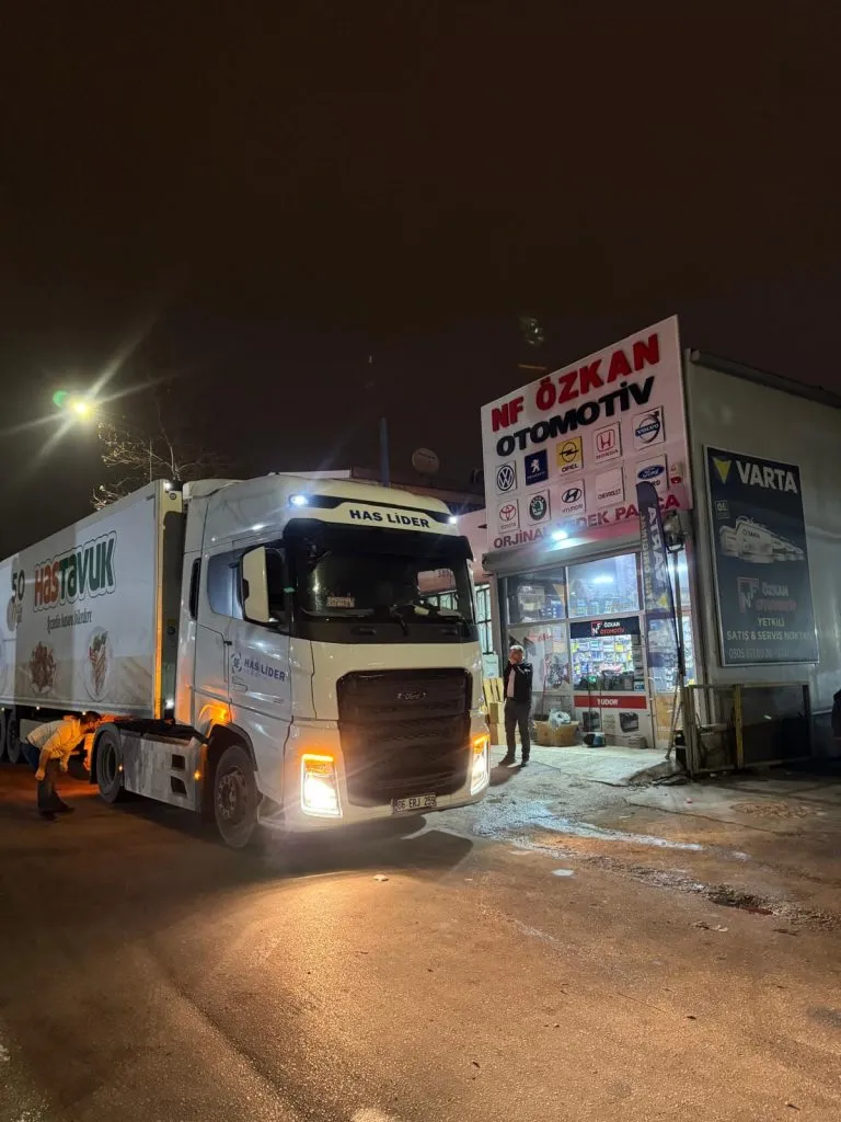 Gece, NF Özkan Otomotiv mağazasının önünde beyaz TIR