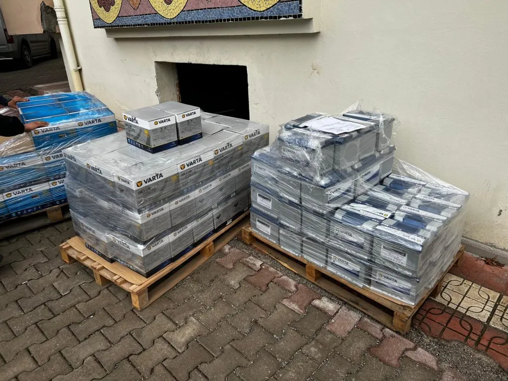 Tuğla zeminli açık alanda streç filmli akü paletleri